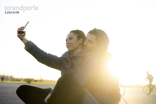Junges Paar  das bei Sonnenuntergang Selfie nimmt