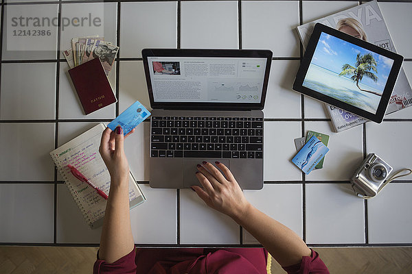 Junge Frau mit Laptop  Bezahlung mit Kreditkarte  Reisebuchung