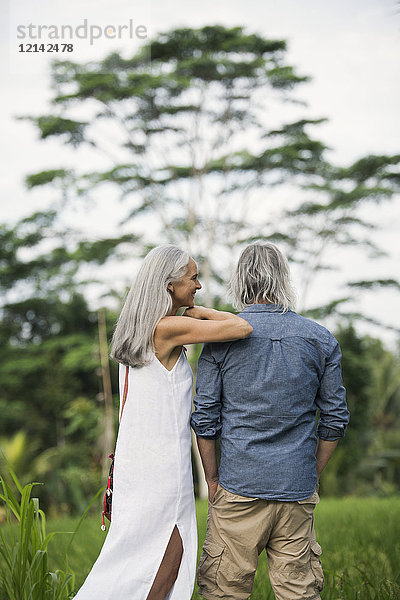 Seniorenpaar mit Blick auf die tropische Landschaft
