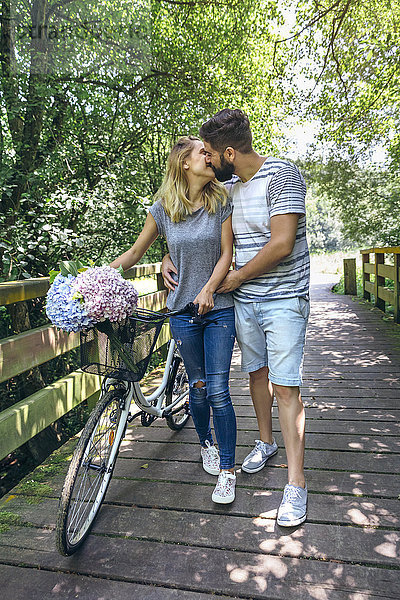 Paar mit Fahrradküssen auf einem Holzsteg in der Natur