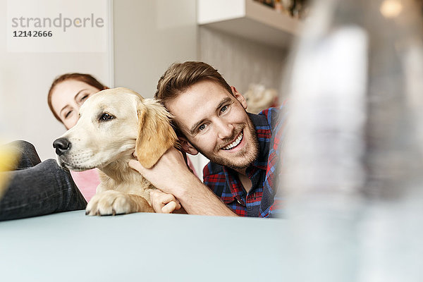 Glückliches junges Paar mit Hund zu Hause