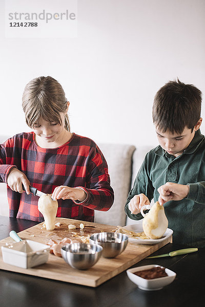 Mädchen und Junge beim Zubereiten von Birnen