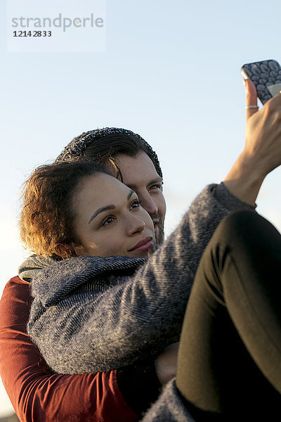 Junges Paar mit Selfie im Freien