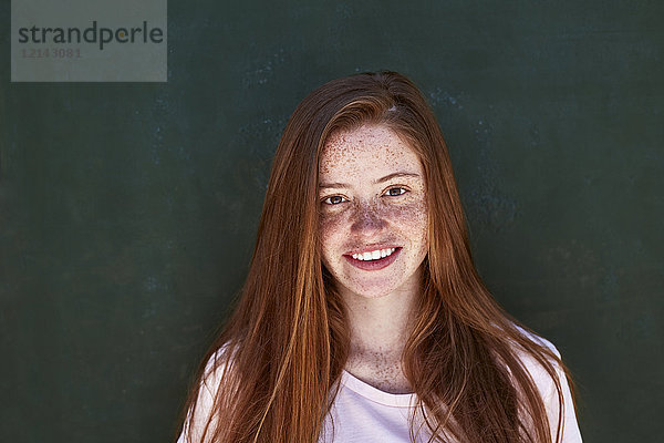 Porträt einer lächelnden jungen Frau mit Sommersprossen