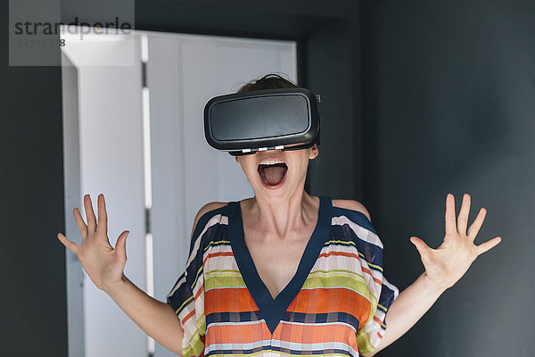Erstaunte Frau mit VR-Brille macht ein verrücktes Gesicht