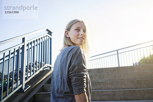 Porträt einer blonden jungen Frau vor der Treppe