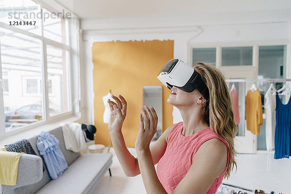 Junge Frau im Modestudio mit VR-Brille