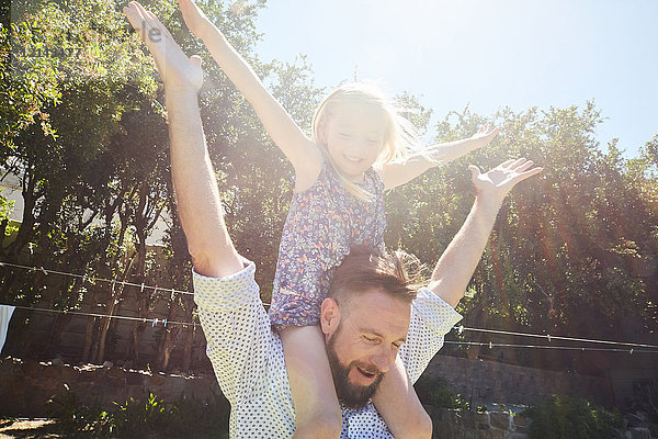 Glücklicher Vater mit Tochter auf den Schultern