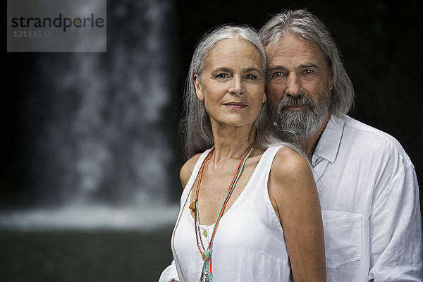 Porträt eines hübschen Seniorenpaares vor dem tropischen Wasserfall