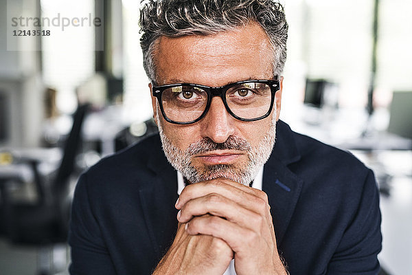 Porträt eines seriösen reifen Geschäftsmannes mit Brille im Büro