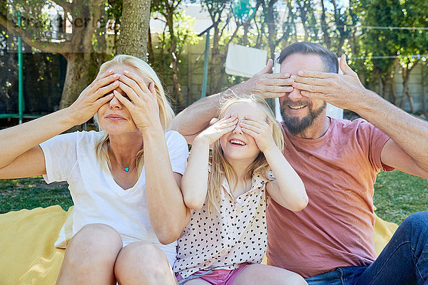 Porträt einer glücklichen Familie  die ihre Augen bedeckt.