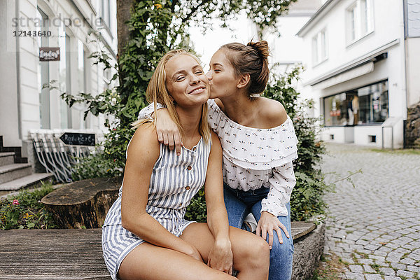 Junge Frau küsst Freundin in der Stadt