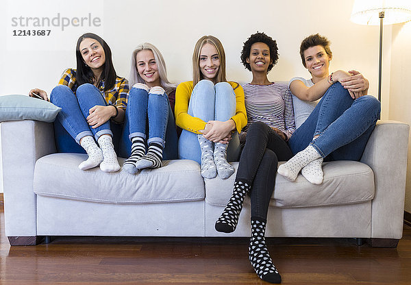 Porträt einer Gruppe von Freundinnen auf dem Sofa im Wohnzimmer