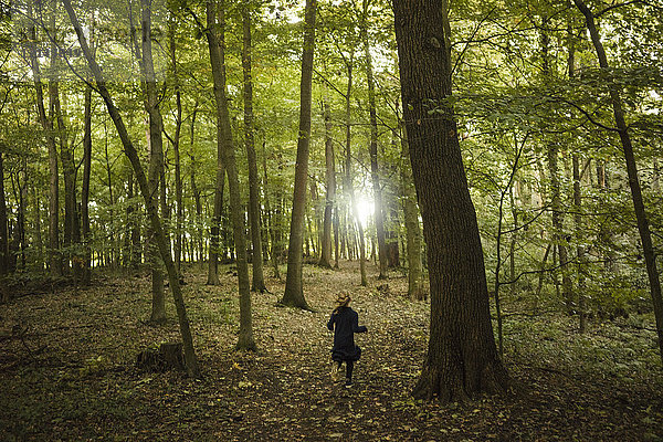 Rückansicht eines im Wald laufenden Mädchens