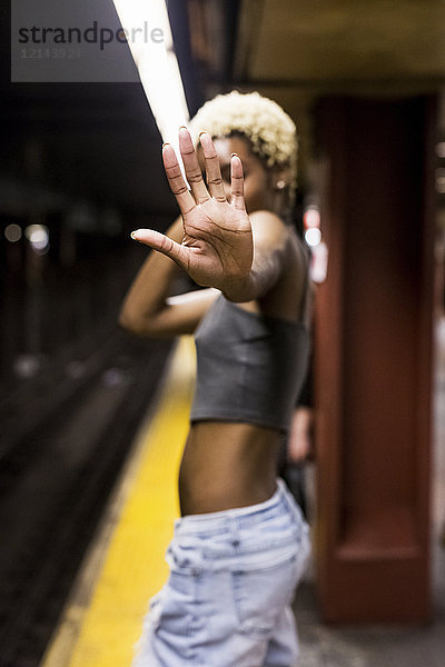 USA  New York City  Frau auf dem Bahnsteig der U-Bahn-Station mit Handfläche