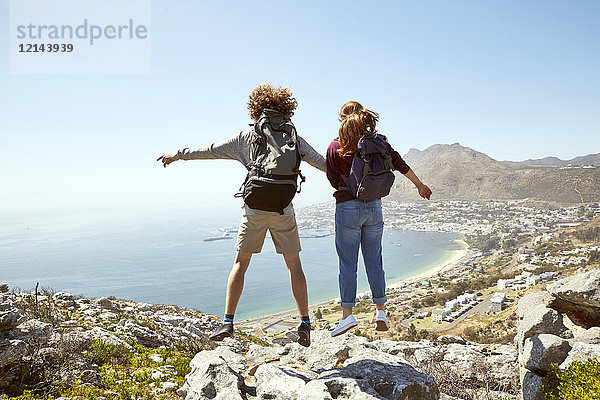 Südafrika  Kapstadt  junges Paar beim Springen an der Küste