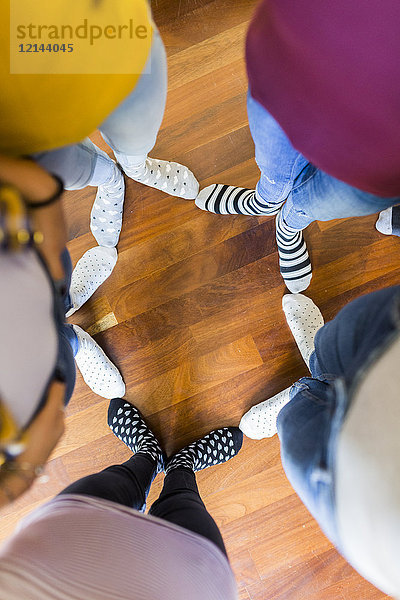 Nahaufnahme der Füße von fünf Frauen auf Holzboden stehend