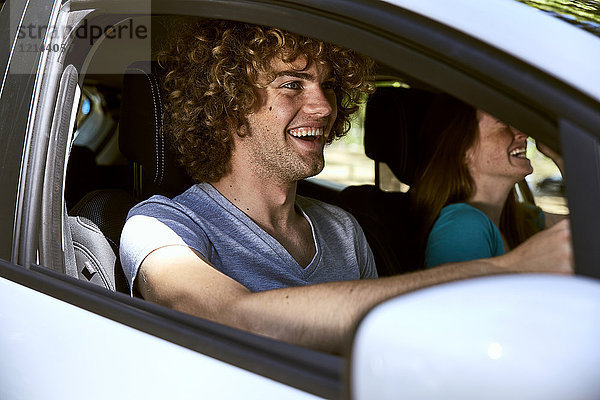 Lachendes junges Paar im Auto