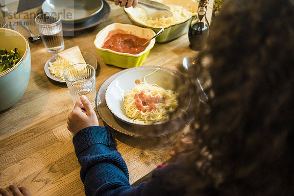 Mädchen essen Spaghetti mit Tomatensauce