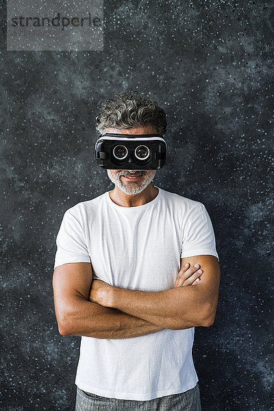 Der reife Mann schaut durch die VR-Brille nach hinten.