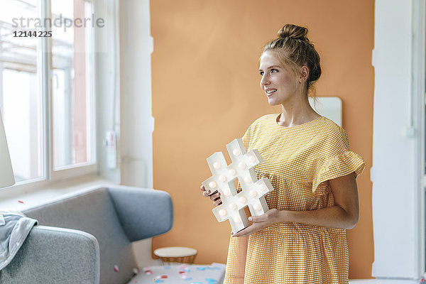 Lächelnde junge Frau mit Hashtag-Schild