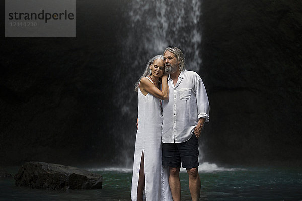 Liebevolles Seniorenpaar vor dem tropischen Wasserfall