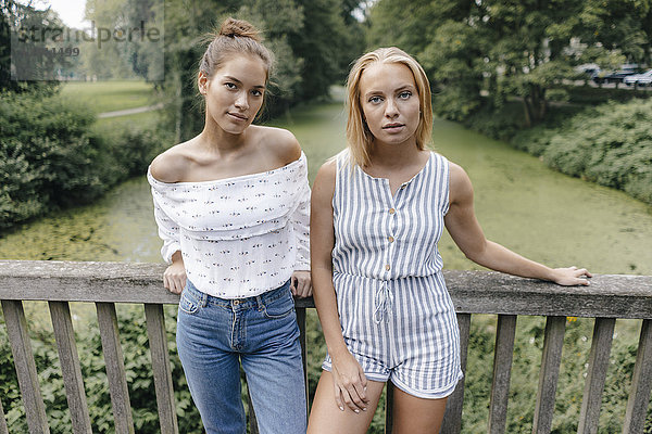 Porträt zweier junger Frauen auf einer Brücke stehend
