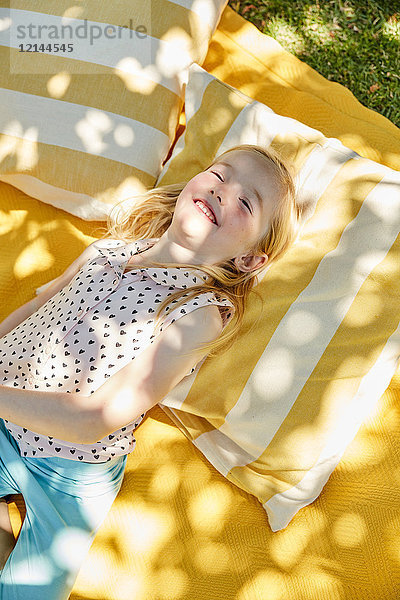 Glückliches Mädchen auf einer Decke liegend