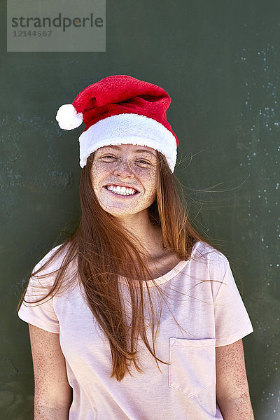 Porträt einer lächelnden jungen Frau mit Weihnachtshut