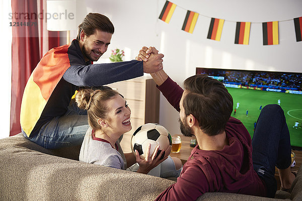 Deutsche Fußballfans beim Fernsehen und Jubeln