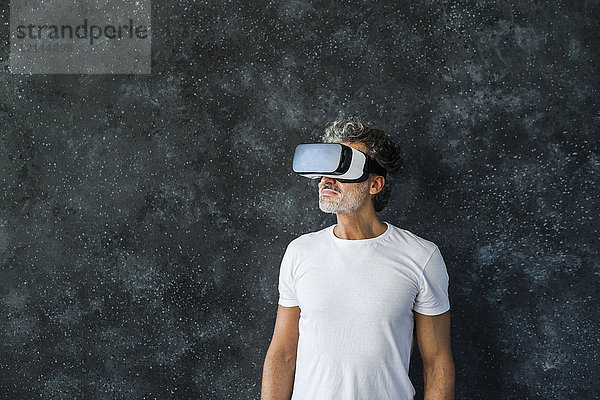 Erwachsener Mann  der durch die VR-Brille schaut