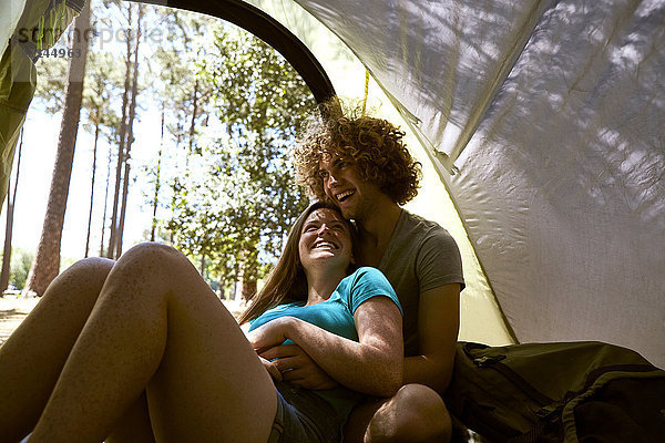 Glückliches junges Paar  das sich in einem Zelt umarmt.