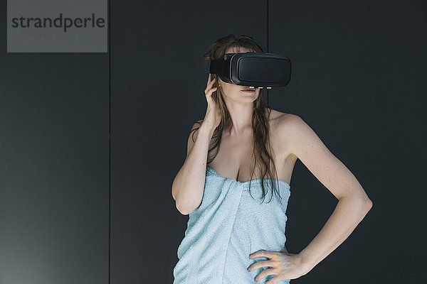 Frau in ein Handtuch gewickelt mit VR-Brille