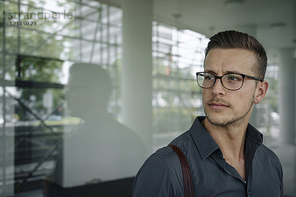Porträt eines nachdenklichen jungen Geschäftsmannes mit Brille