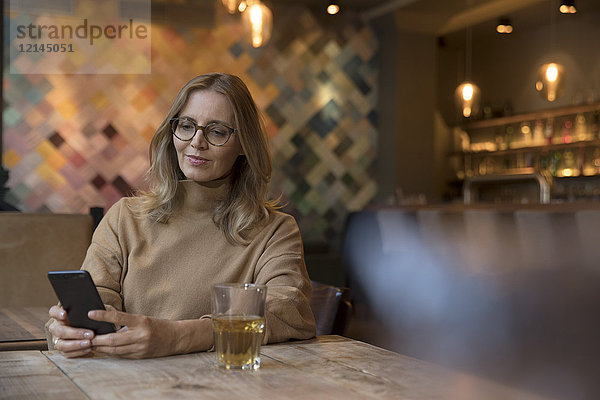 Portrait einer Geschäftsfrau im Restaurant mit Handy