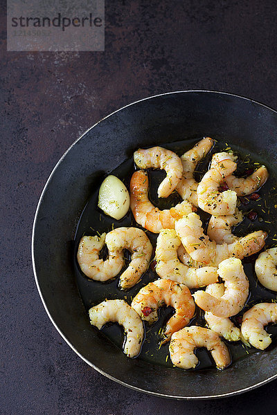 Garnelen in der Pfanne mit Öl  Knoblauch und Kräutern braten