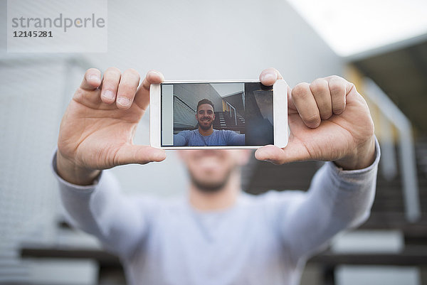 Lächelnder Mann nimmt Selfie mit Handy  Nahaufnahme