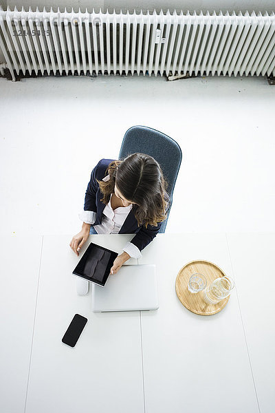 Geschäftsfrau am Schreibtisch im Büro bei der Arbeit am Tablett  Draufsicht