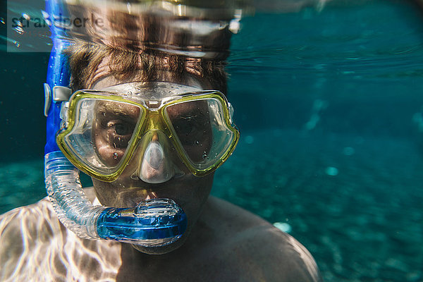 Porträt eines Mannes mit Taucherbrille und Schnorchel unter Wasser im Schwimmbad