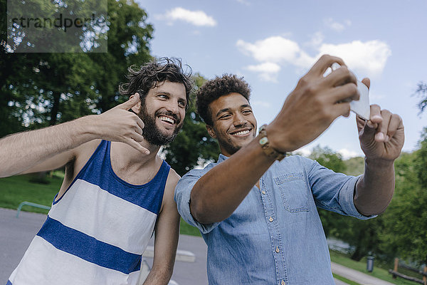 Zwei glückliche Freunde  die einen Selfie in einem Skatepark nehmen.