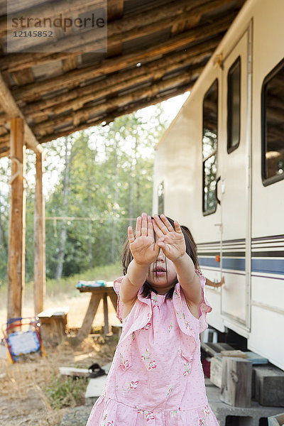 Portrait schüchternes Mädchen versteckt Gesicht mit den Händen außerhalb der ländlichen Camper