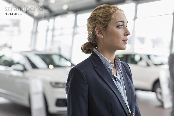 Nachdenkliche Autoverkäuferin im Autohaus-Showroom