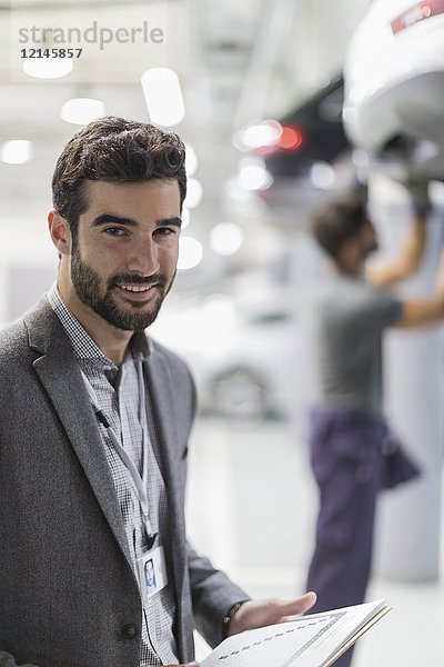 Portrait lächelnder  selbstbewusster Mann in der Autowerkstatt