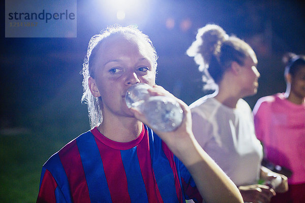 Junge Fußballspielerin beim Trinken aus der Wasserflasche