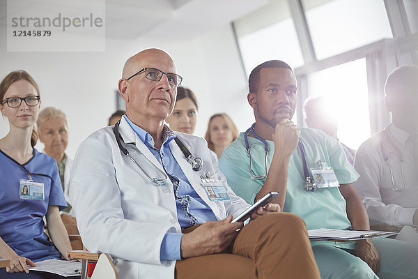 Aufmerksame Chirurgen  Ärzte und Krankenschwestern beim Zuhören in der Konferenz