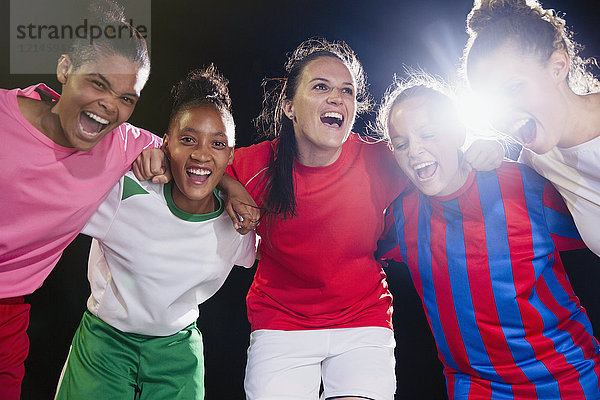 Portrait begeisterte  selbstbewusste junge Fußballmannschaft  die sich zusammenschließt und jubelt.