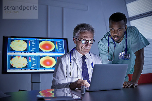 Chirurg und Arzt bei der Arbeit am Laptop im Konferenzraum des Krankenhauses