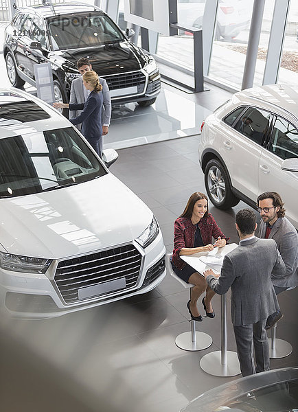 Autoverkäufer treffen sich am Tisch im Autohaus-Showroom
