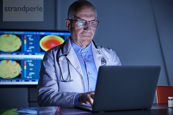 Fokussierter Chirurg am Laptop im Krankenhaus