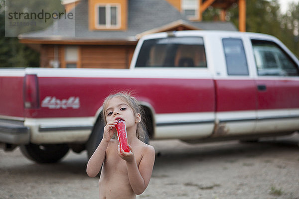 Portrait nacktes Mädchen trinkt Saft in der Nähe von Pickup-Trick